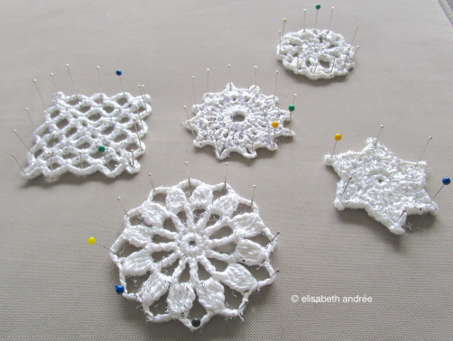 white crochet motifs with glittter pinned and drying